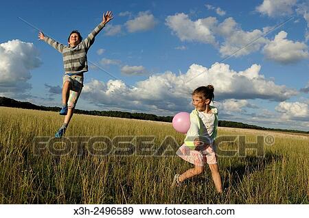 young boy with his sister running with balloons in a field, Ile-de-France, France, Europe. View Large Photo Image Stock Photo - young boy with his sister running with balloons in a field, Ile-de-France, France, Europe.. Fotosearch