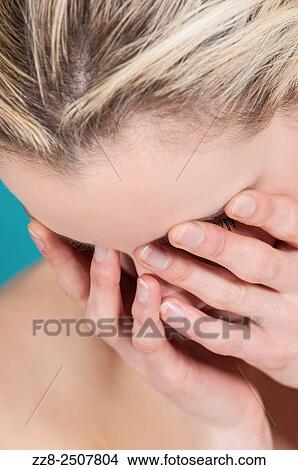 Picture - Young Caucasian woman hiding face with hands.. Fotosearch