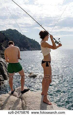 Young couple fishing at sea in the morning, Tossa de Mar, Catalonia, Spain, Europe. View Large Photo Image Stock Photograph - Young couple fishing at sea in the morning, Tossa de Mar, Catalonia, Spain, Europe.. Fotosearch