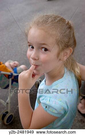 Stock Photo - Young girl looking coy with finger in her mouth. Fotosearch