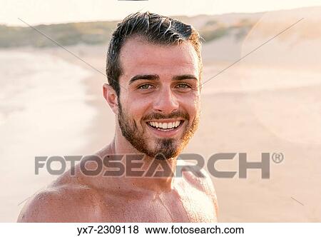 Young man at the beach smiling. View Large Photo Image Stock Photo - Young man at the beach smiling.. Fotosearch