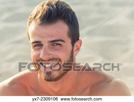 Young man at the beach smiling. View Large Photo Image Stock Photograph - Young man at the beach smiling.. Fotosearch