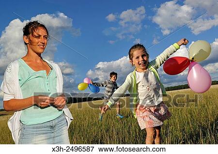 young mother playing with her two children playing with balloons, Ile-de-France, France, Europe. View Large Photo Image Stock Photo - young mother playing with her two children playing with balloons, Ile-de-France, France, Europe.. Fotosearch