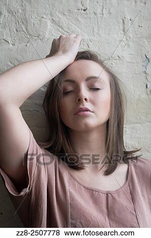 Stock Photo - Young woman hand on head in pain.. Fotosearch