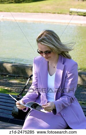 Stock Photography - young woman reading on a park bench.. Fotosearch