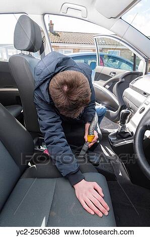 Stock Photo - A 15 year old teenage boy cleaning the interior of a car to earn money.. Fotosearch