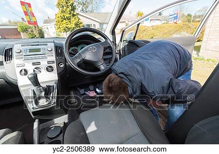 Stock Photo - A 15 year old teenage boy cleaning the interior of a car to earn money.. Fotosearch