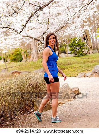 A 22 year old brunette woman jogging in a garden. View Large Photo Image Stock Image - A 22 year old brunette woman jogging in a garden.. Fotosearch