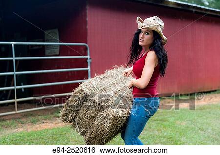 A 38 year old brunette woman carrying a bale of hay. View Large Photo Image Stock Photograph - A 38 year old brunette woman carrying a bale of hay.. Fotosearch