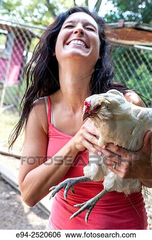 A 38 year old brunette woman holding a white chicken on a farm. View Large Photo Image Stock Photograph - A 38 year old brunette woman holding a white chicken on a farm.. Fotosearch