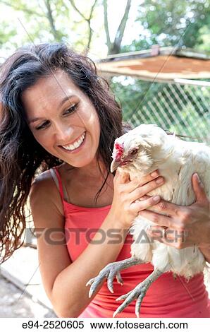 A 38 year old brunette woman holding a white chicken on a farm. View Large Photo Image Stock Photography - A 38 year old brunette woman holding a white chicken on a farm.. Fotosearch