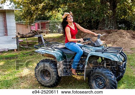 A 38 year old brunette woman riding an ATV on a farm. View Large Photo Image Stock Image - A 38 year old brunette woman riding an ATV on a farm.. Fotosearch