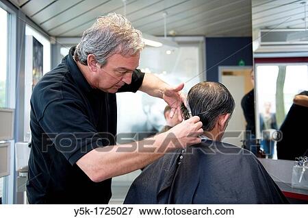 A barber giving a male customer a haircut. View Large Photo Image Stock Photo - A barber giving a male customer a haircut.. Fotosearch
