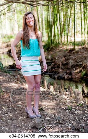 A smiling 22 year old woman outdoors dressed in a mini-skirt and heels. View Large Photo Image Stock Photo - A smiling 22 year old woman outdoors dressed in a mini-skirt and heels.. Fotosearch