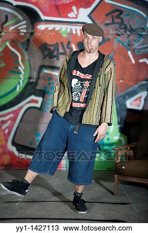A young man with cap posing in front of a large graffity. View Large Photo Image Stock Image - A young man with cap posing in front of a large graffity.. Fotosearch