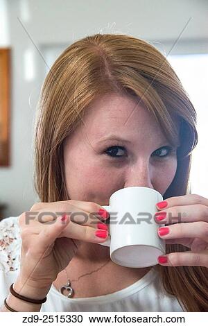 A young woman sips her coffee. View Large Photo Image Stock Image - A young woman sips her coffee.. Fotosearch