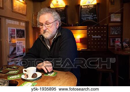 An older man, former owner of the oldest cafe in Tilburg, called Weemoed, at the bar with a cup of coffee. View Large Photo Image Stock Photography - An older man, former owner of the oldest cafe in Tilburg, called Weemoed, at the bar with a cup of coffee.. Fotosearch