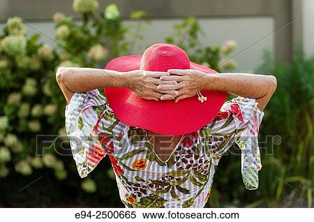 Back view of a 56 year old blond woman wearing a red hat and a casual summer top. View Large Photo Image Stock Photography - Back view of a 56 year old blond woman wearing a red hat and a casual summer top.. Fotosearch