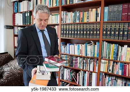 Breda, Netherlands. Wine broker reading books and references in his library at home. View Large Photo Image Stock Image - Breda, Netherlands. Wine broker reading books and references in his library at home.. Fotosearch