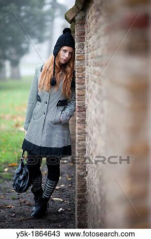 Breda, Netherlands. Young, fashionable and redheaded woman in a city-park, leaning against a wall. View Large Photo Image Stock Image - Breda, Netherlands. Young, fashionable and redheaded woman in a city-park, leaning against a wall.. Fotosearch