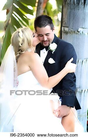 Stock Image - Bride and groom enjoying an intimate moment after the wedding in a garden. Fotosearch