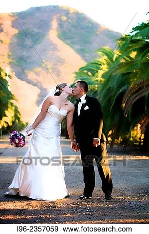 Bride and groom stopping to kiss in a beautiful scenic mountain area View Large Photo Image Stock Photo - Bride and groom stopping to kiss in a beautiful scenic mountain area. Fotosearch