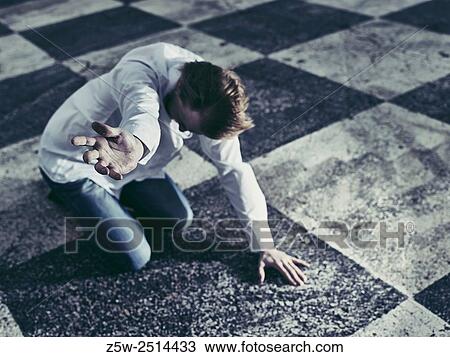 Stock Image - Conceptual, humble man and checkered ground.. Fotosearch