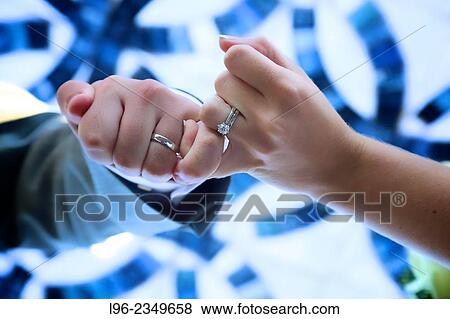 Couple holding hands showing off their wedding rings View Large Photo Image Stock Photo - Couple holding hands showing off their wedding rings. Fotosearch