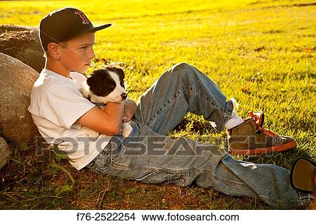 Eight year old boy cuddling, loving holding his young border collie mixed breed puppy dog. MR# 120818_2. View Large Photo Image Picture - Eight year old boy cuddling, loving holding his young border collie mixed breed puppy dog. MR# 120818_2.. Fotosearch