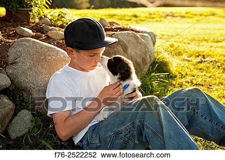 Eight year old boy cuddling, loving holding his young border collie mixed breed puppy dog. MR# 120818_2.. View Large Photo Image Stock Image - Eight year old boy cuddling, loving holding his young border collie mixed breed puppy dog. MR# 120818_2... Fotosearch