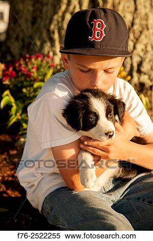 Eight year old boy cuddling, loving holding his young border collie mixed breed puppy dog. MR# 120818_2.. View Large Photo Image Stock Photography - Eight year old boy cuddling, loving holding his young border collie mixed breed puppy dog. MR# 120818_2... Fotosearch