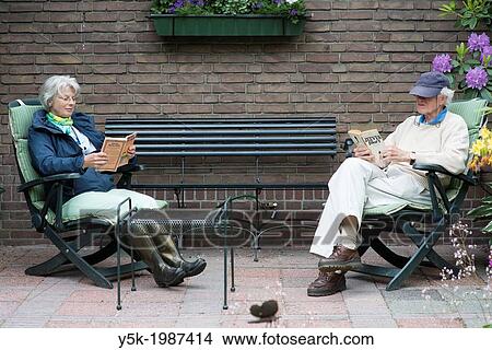 Hilligersberg, Rotterdam, Netherlands. Older couple, together reading a book, in their garden behind their house. View Large Photo Image Picture - Hilligersberg, Rotterdam, Netherlands. Older couple, together reading a book, in their garden behind their house.. Fotosearch