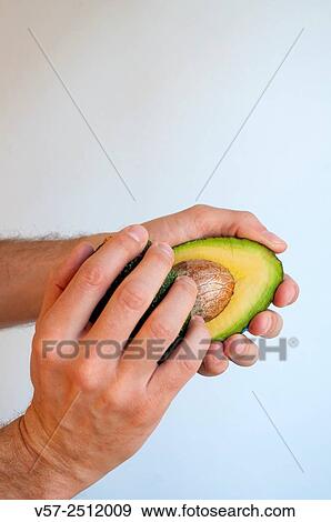 Man´s hands opening an avocado in two halves. Close view. View Large Photo Image Stock Photo - Man´s hands opening an avocado in two halves. Close view.. Fotosearch