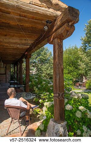 Picture - Man sitting in a terrace in a rural hotel. Segovia, Spain.. Fotosearch