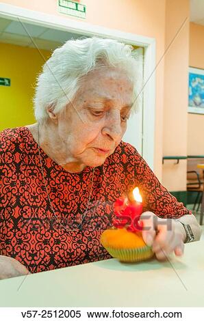 Old woman in a nursing home, on her ninety one birthday, blowing birthday´s candles. View Large Photo Image Stock Photography - Old woman in a nursing home, on her ninety one birthday, blowing birthday´s candles.. Fotosearch