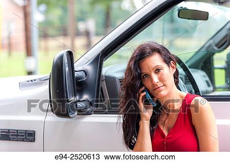 Portrait of a 38 year old brunette woman talking on a cell phone standing by a white pick up truck. View Large Photo Image Stock Image - Portrait of a 38 year old brunette woman talking on a cell phone standing by a white pick up truck.. Fotosearch