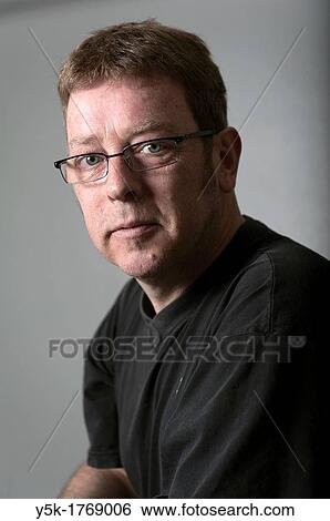 Portrait of a man with glasses against a grey background. View Large Photo Image Stock Photograph - Portrait of a man with glasses against a grey background.. Fotosearch