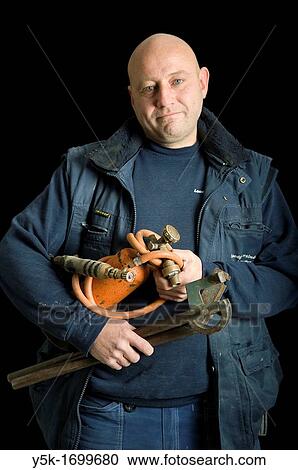 Portrait of a plumber, with his torch, in front of a black background. Photograph - portrait taken during the reconstruction of a bathroom. View Large Photo Image Stock Image - Portrait of a plumber, with his torch, in front of a black background. Photograph - portrait taken during the reconstruction of a bathroom.. Fotosearch
