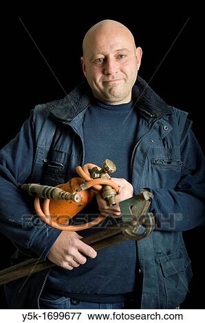 Portrait of a plumber, with his torch, in front of a black background. Photograph - portrait taken during the reconstruction of a bathroom. View Large Photo Image Stock Photo - Portrait of a plumber, with his torch, in front of a black background. Photograph - portrait taken during the reconstruction of a bathroom.. Fotosearch