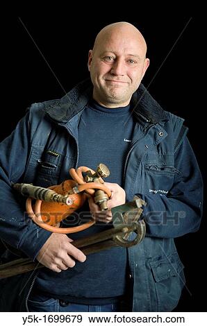 Portrait of a plumber, with his torch, in front of a black background. Photograph - portrait taken during the reconstruction of a bathroom. View Large Photo Image Stock Photo - Portrait of a plumber, with his torch, in front of a black background. Photograph - portrait taken during the reconstruction of a bathroom.. Fotosearch