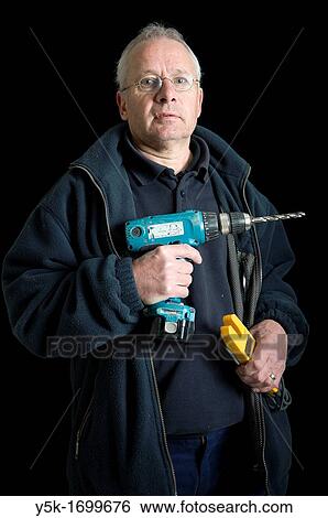 Portrait of an electrician, with his drill and other tools, in front of a black background. Photograph - portrait taken during the reconstruction of a bathroom. View Large Photo Image Stock Photograph - Portrait of an electrician, with his drill and other tools, in front of a black background. Photograph - portrait taken during the reconstruction of a bathroom.. Fotosearch