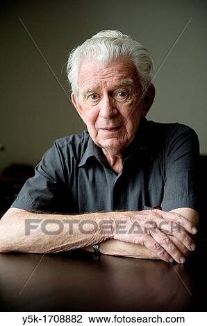 Stock Image - Portrait of an older, Dutch man, sitting at a diner-table.. Fotosearch