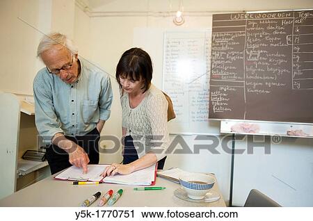 Rotterdam, Netherlands. A retired language teacher volunteers to educate undocumented aliens in The Netherlands into the Dutch Language, Meanwhile consulting with his female coworker. View Large Photo Image Stock Image - Rotterdam, Netherlands. A retired language teacher volunteers to educate undocumented aliens in The Netherlands into the Dutch Language, Meanwhile consulting with his female coworker.. Fotosearch