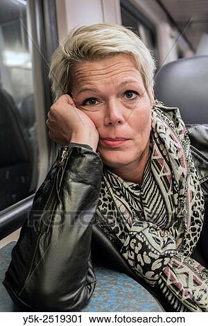 Rotterdam, Netherlands. Blonde, caucasian female commuting home by train, after a day of hard work. View Large Photo Image Stock Image - Rotterdam, Netherlands. Blonde, caucasian female commuting home by train, after a day of hard work.. Fotosearch