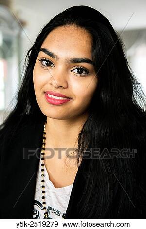 Rotterdam, Netherlands. Portrait of a young, attractive Hinsoestan woman, while having a conversation in het living room. View Large Photo Image Stock Photo - Rotterdam, Netherlands. Portrait of a young, attractive Hinsoestan woman, while having a conversation in het living room.. Fotosearch