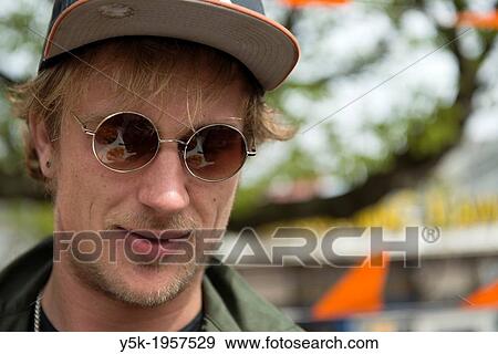 Rotterdam, Netherlands. Street-portrait of a young caucasian man with cap and glasses. View Large Photo Image Stock Photo - Rotterdam, Netherlands. Street-portrait of a young caucasian man with cap and glasses.. Fotosearch