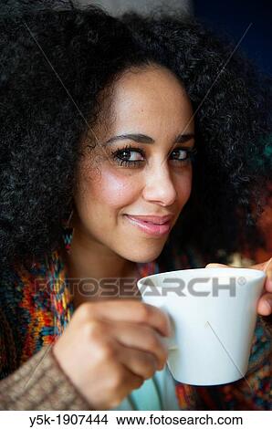 Rotterdam, Netherlands. Young African woman having a huge cup of coffee, while smiling and enjoying the moment View Large Photo Image Picture - Rotterdam, Netherlands. Young African woman having a huge cup of coffee, while smiling and enjoying the moment. Fotosearch
