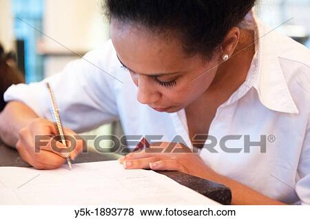 Stock Photo - Rotterdam, Netherlands. Young, colored waitress, signing a model release, after serving a customer in a grand-cafe restaurant, down town Rotterdam.. Fotosearch