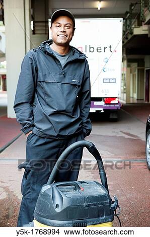Rotterdam, Netherlands. Young Indonesian man, working as a cleaner for a rental firm of cars. View Large Photo Image Picture - Rotterdam, Netherlands. Young Indonesian man, working as a cleaner for a rental firm of cars.. Fotosearch