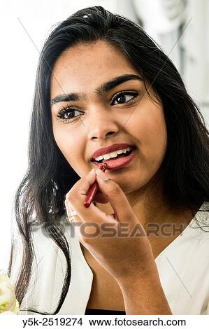 Rotterdam, Netherlands. Young, attractive Hindustani woman, at home applying makeup to her face. View Large Photo Image Picture - Rotterdam, Netherlands. Young, attractive Hindustani woman, at home applying makeup to her face.. Fotosearch